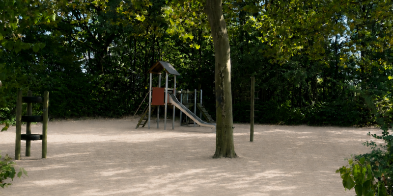 Ein Spielplatz unter Bäumen.
