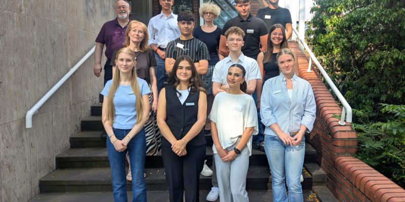 Menschen stehen hintereinander auf einer Treppe.