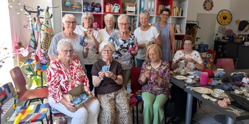 Einige Damen sitzen zusammen in einem Handarbeitsraum und häkeln.